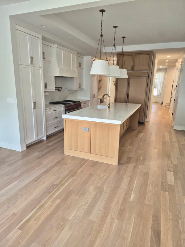 Kitchen remodel with white cabinets, a rift white oak island and a quartz waterfall countertop