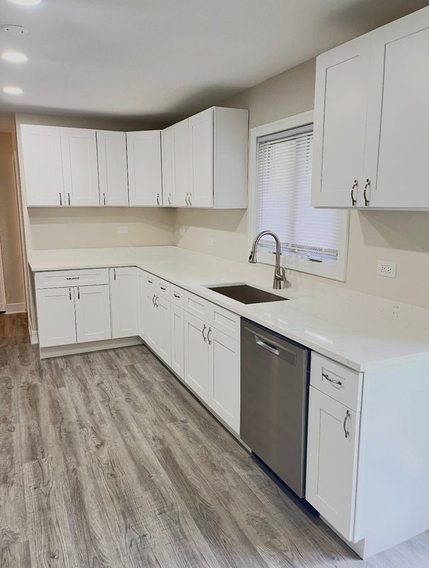 Kitchen remodel with white shaker cabinets, quartz countertops and a stainless undermount sink