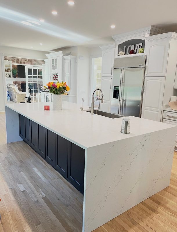 Quartz countertop with a waterfall edge on a navy kitchen island